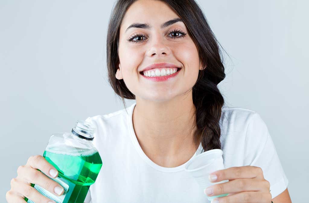 Girl using mouthwash recommended to her by her dentist